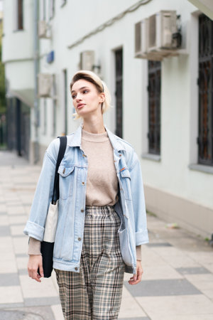 Outdoor portrait of beautiful young woman in casual clothes walking in the cityの写真素材