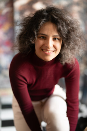 Portrait of a beautiful young woman with curly hair smiling at the cameraの写真素材