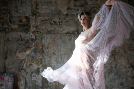 Young beautiful ballerina in a white tutu posing in the studioの写真素材