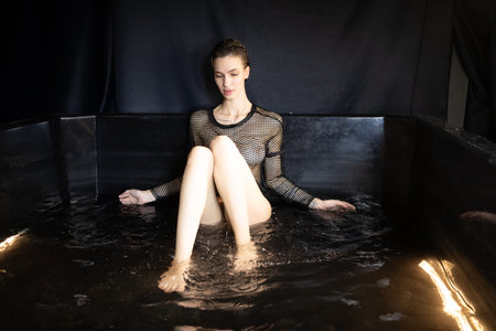 Beautiful young woman relaxing in a bathtub at spa centre.の写真素材