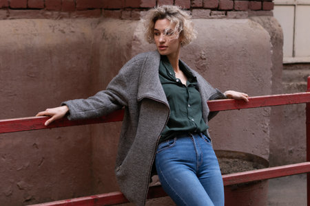 Outdoor portrait of young beautiful girl posing on the street. Model wearing fashionable clothes.の写真素材