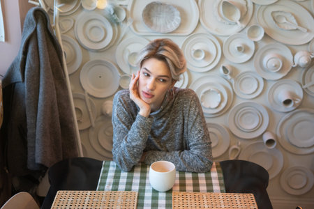 Beautiful woman sitting in a cafe with a cup of coffee.の写真素材