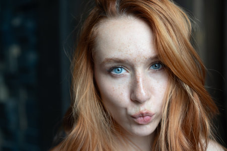 Portrait of a red-haired girl with freckles on her faceの写真素材