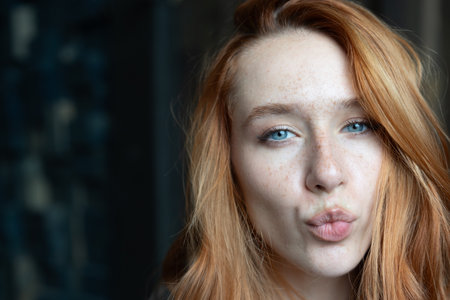 Portrait of a red-haired girl with freckles on her faceの写真素材