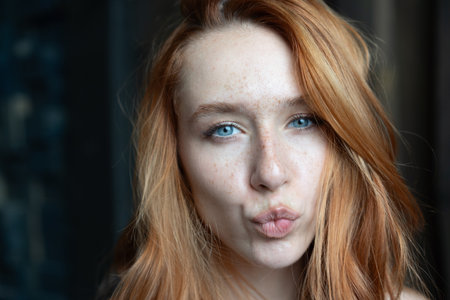 Portrait of a red-haired girl with freckles on her faceの写真素材