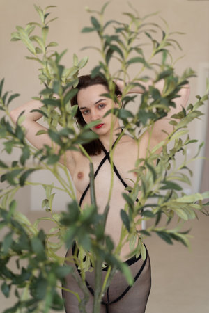 young girl posing in studio, standing in black lingerieの写真素材