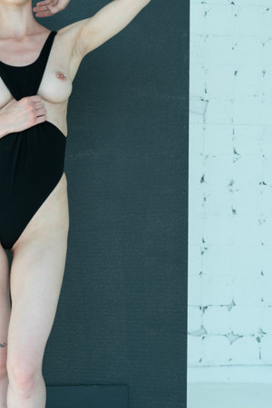 young beautiful girl posing in studio, standing in black swimsuitの写真素材