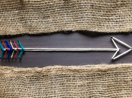 Arrow on wooden background and burlap background