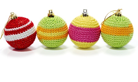 Row of colourful balls made of knitted wool. Free space for text. Studio shot on a white background, not isolated.の写真素材