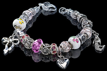 Close-up view to handmade charm modular beads and gems bracelet on blackの写真素材
