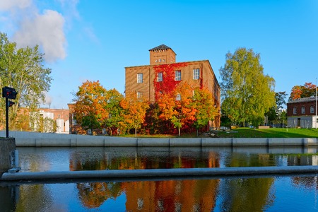 Old factory buildings of red brick by the canal at Myllysaari at sunny autumn day. Valkeakoski, Finlandのeditorial素材