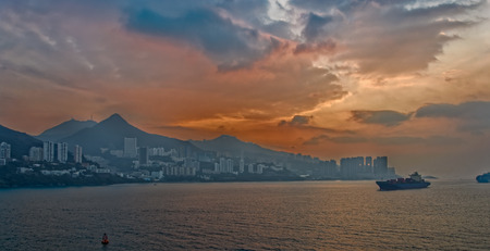 Panoramic view to sunrise over a Hong Kong, taken from the sea with dramatic clouds.の写真素材
