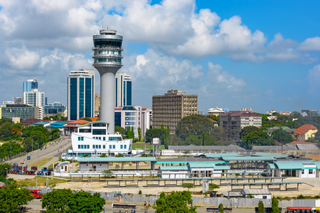 Modern glass skyscrapers stand alongside older buildings in Dar Es Salaam with maritime control tower on foregroundの写真素材