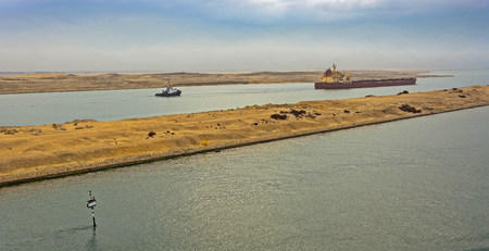 Loaded Bulk carrier passing through Suez Canal with ship's convoy at early morning.の写真素材