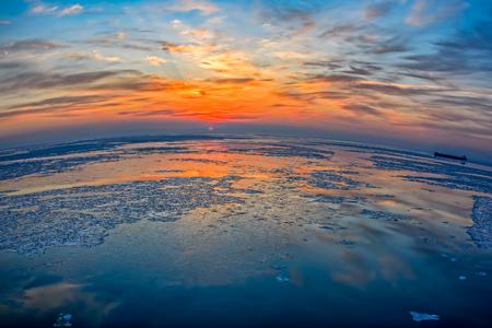 Wide angle view to ice floes in Bohai Sea or Bo Sea, also known as Bohai Gulf or Bo Gulf, at sunset