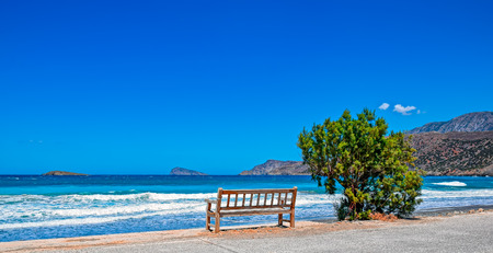 Alone wooden bench on the Mediterranean sea shore. Crete, Greeceの写真素材