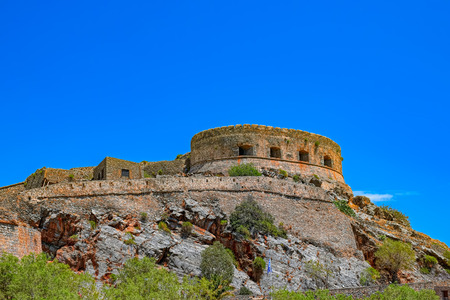 Ruins of main tower of medieval fortress Spinalonga on island Kalydon, Greece.