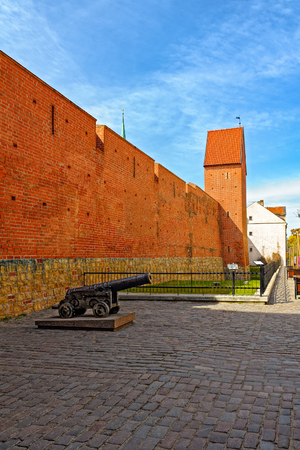 The red brick defensive town wall, old cannon and ramparts opposite the quarters of Jacobs Barracks, Riga, Latviaのeditorial素材