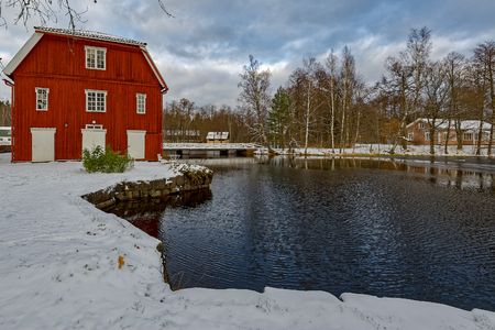 Traditional red ochre painted colour wooden houses at former Stromfors Iron Works, Finland covered first snowの写真素材