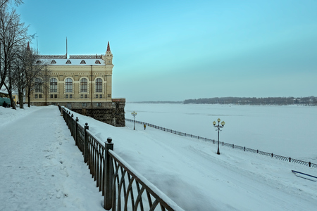 View of the Volga embankment, snow covered promenade and a building of former new Rybinsk grain stock exchange.のeditorial素材
