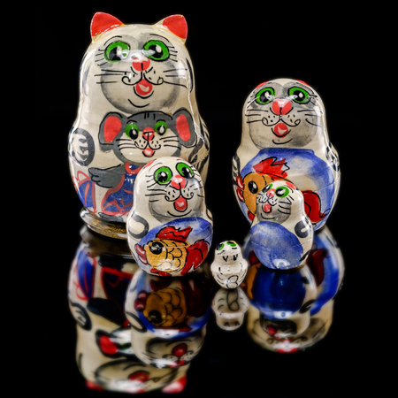 Set of Russian nesting dolls (babushkas or matryoshkas) in shapes of cat family on black mirrorの写真素材