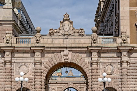 Lion heads and Swedish Royal coat of arms on arched passageway in the Riksgatan district of Stockholm, Swedenの写真素材