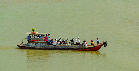 HO CHI MINH CITY (SAIGON), VIETNAM - Jan 29, 2017: Sampan flat bottom wooden boat with full load of walking and riding passengers transits on Saigon River.のeditorial素材