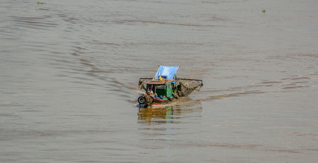 HO CHI MINH CITY (SAIGON), VIETNAM - Feb 27, 2017: Traditional fisherman's wooden houseboat  with painted eyes on the bow and the fishing net on the aft on Saigon River.のeditorial素材