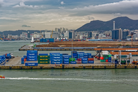 BUSAN, SOUTH KOREA - Dec 22, 2016: View from the sea to the cargo berths of the Port of Busan, Korea's busiest and the 10th-busiest in the world, in front of residential multistorey buildings.のeditorial素材