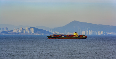 Heavy laden container vessel departs from port Busan on delivery.の写真素材