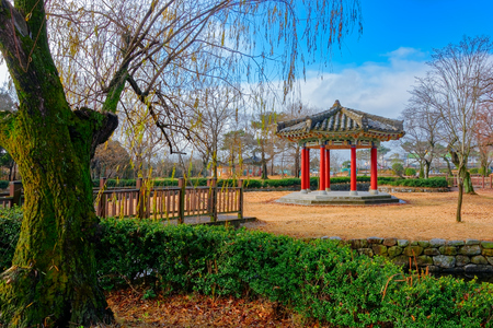 Wooden bridge to a small island with a gazebo in the middle of a pond in an autumn parkの写真素材