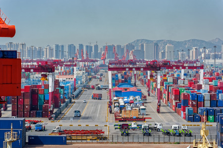 QINGDAO, CHINA - May 15, 2017: Qianwan container terminal with city skyline in the background at Qingdao.のeditorial素材