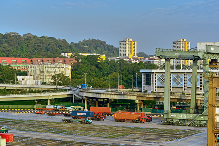 SINGAPORE, MALAYSIA - Mar 10, 2017: Sunset view of highrise residential buildings behind of Port of Singapore container cargo terminal, run by PSA, one of the busiest shipping terminals in the world.のeditorial素材