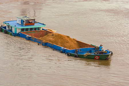 HO CHI MINH CITY (SAIGON), VIETNAM - Dec 30, 2016: Overloaded dredging barge carrying sand on the Saigon river.のeditorial素材