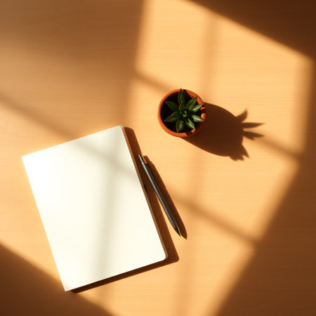 Top view of blank paper with pen and plant on wooden table.の素材