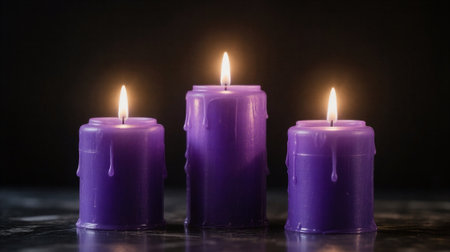 Three purple candles on a black background with a shallow depth of fieldの素材
