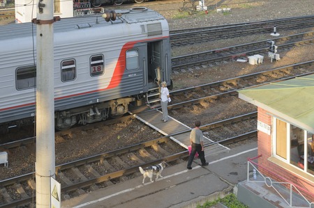 Conductor standing near the car before the departure of a passenger train from the station.のeditorial素材
