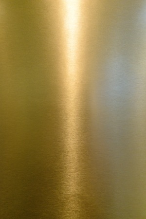 Detail of shiny polished metal surface golden (yellow) color with highlights