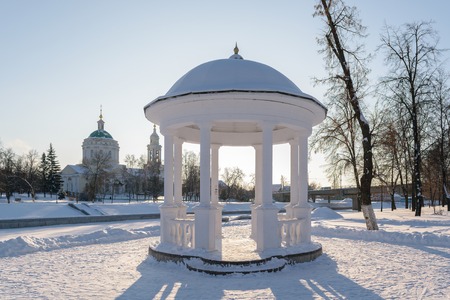 White arbor with the columns, standing on the shore of frozen river  in winter.の写真素材