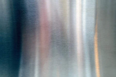 Convex polished shiny steel metal surface with multicolored reflections and glareの写真素材