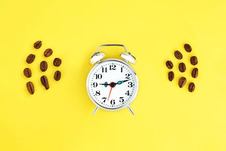 Metal vintage alarm clock with office pen on colorful paper background. Work and planning time lat...