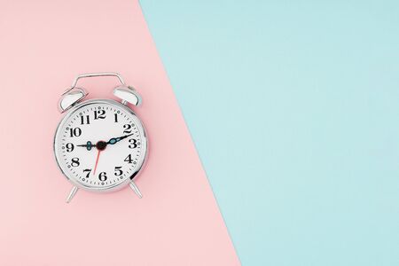 Metal vintage alarm clock with on sections of colorful paper background. Work and planning time flat lay conceptの写真素材