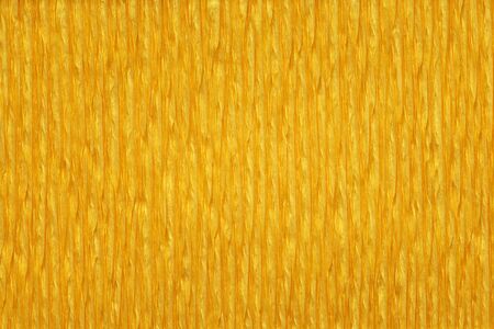 Yellow wrinkled crepe paper vertical close-up detail. Front viewの写真素材