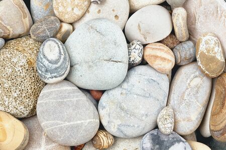 Mix of rounded multicolor textured stones on sea beach . Close up coast shootの写真素材