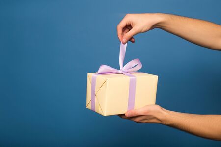 cropped view of man unpacking gift box isolatedの写真素材