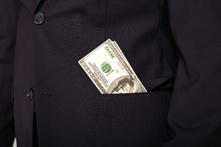 cropped view of successful young businessman in black suit with money in pocketの写真素材