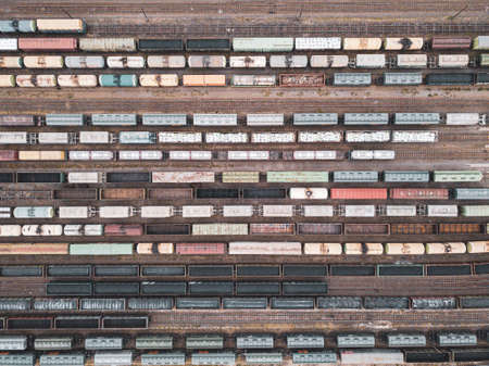 Aerial view of freight trains. Railway cargo wagons with goods on railroad. Top view of colorful freight train on the railway station. Heavy industry. Industrial scene. Transportationの写真素材