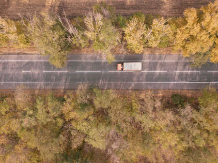 Asphalt highway or motorway road in countryside and truck traffic Cargo Semi Trailer Moving. Aerial Top Viewの写真素材