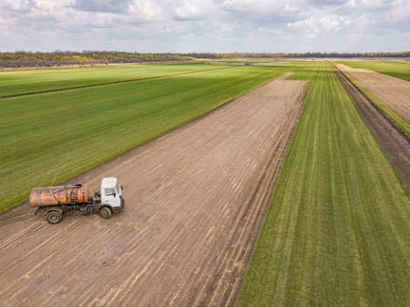 aerial drone photo. Green meadow farmland field with sprayer truck. Russia.の写真素材