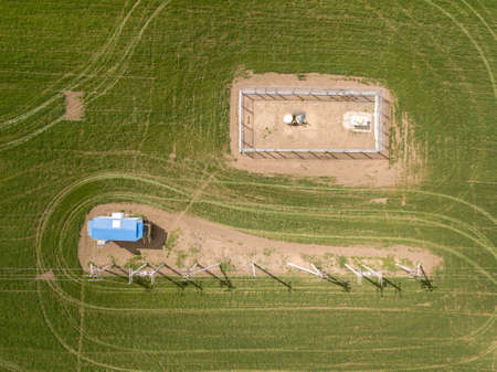 Aerial top down drone photo. Electic lines and electric transformer among green lawn.の写真素材